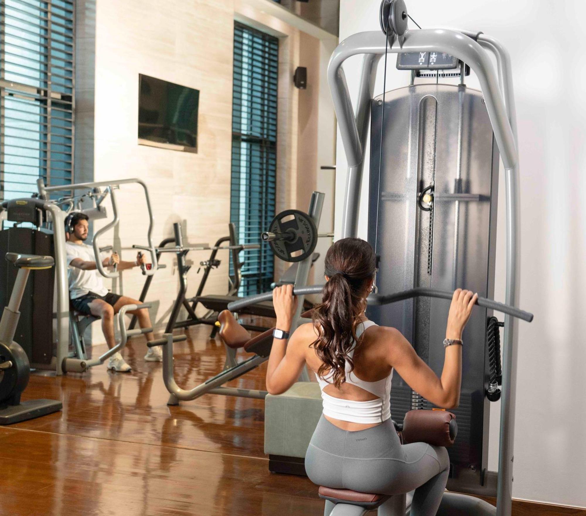 페어몬트 리야드 호텔 외부 사진 A woman using a lat pulldown machine